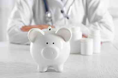 © Africa Studio - stock.adobe.com Arzt hinter Sparschwein