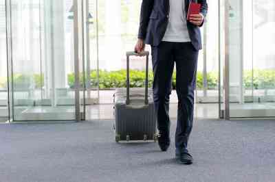 Mann mit Koffer am Flughafen